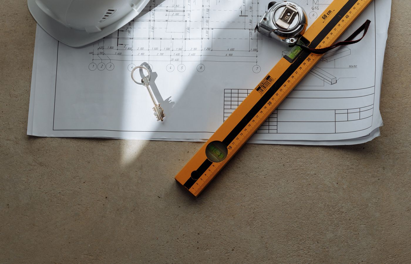 Construction plans, hard hat and measuring tools used for project estimating