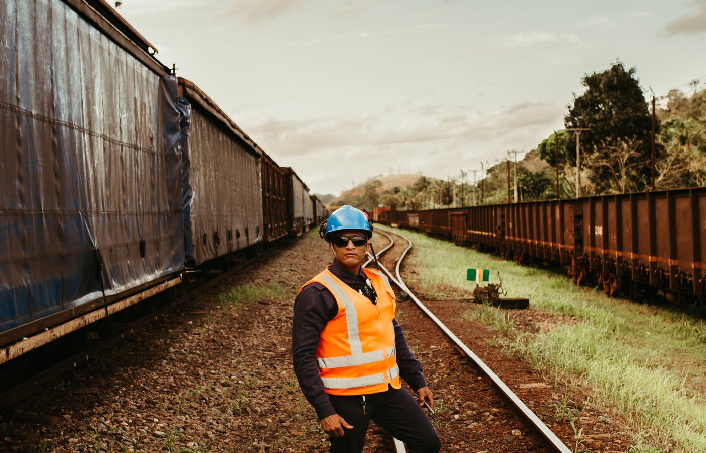 Track inspector in high visibility clothing walking track between freight cars