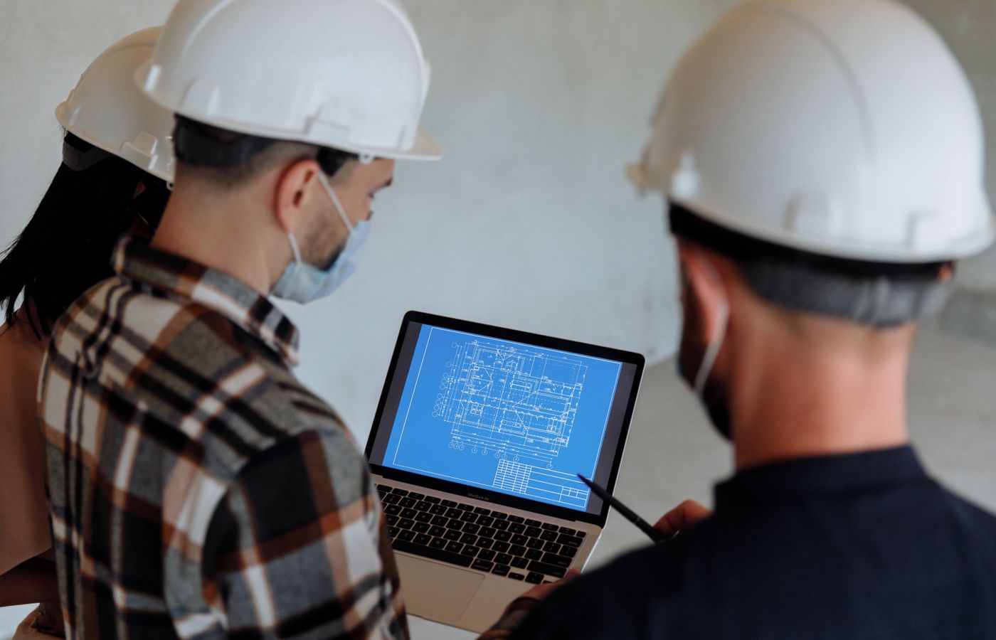 Project team in hard hats reviewing construction plans on site